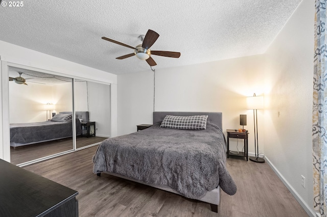 bedroom with a ceiling fan, a closet, a textured ceiling, and wood finished floors