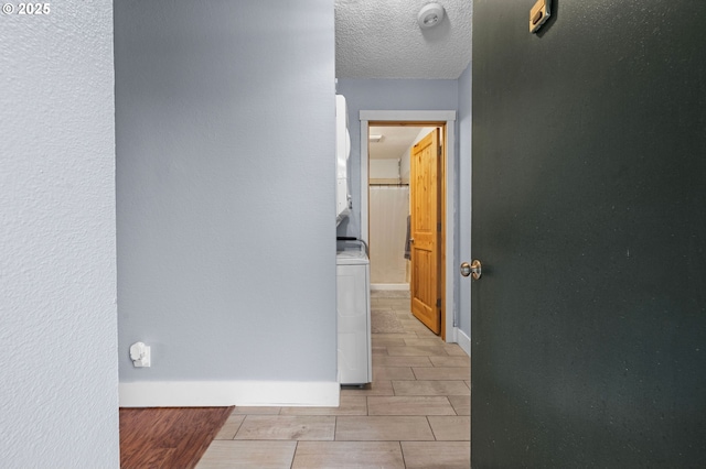 hallway with a textured ceiling and baseboards