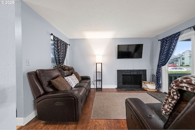 living room with a fireplace, wood finished floors, and baseboards