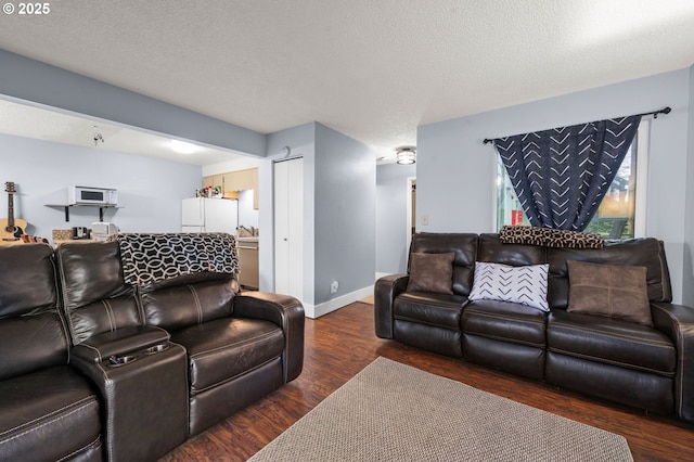 living area with a textured ceiling, baseboards, and wood finished floors