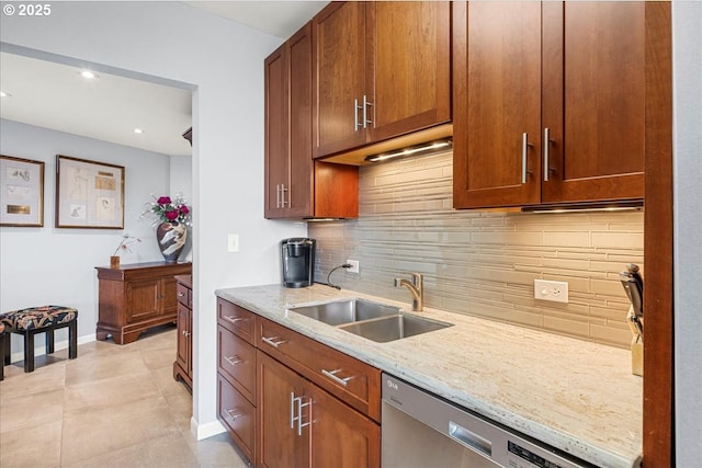 kitchen with light tile patterned floors, light stone counters, backsplash, stainless steel dishwasher, and a sink