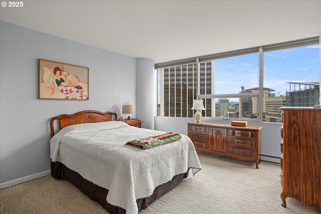 bedroom featuring a baseboard radiator, light carpet, a city view, and baseboards