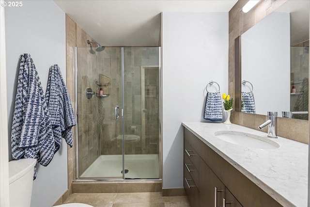 bathroom with toilet, tile patterned floors, a shower stall, and vanity