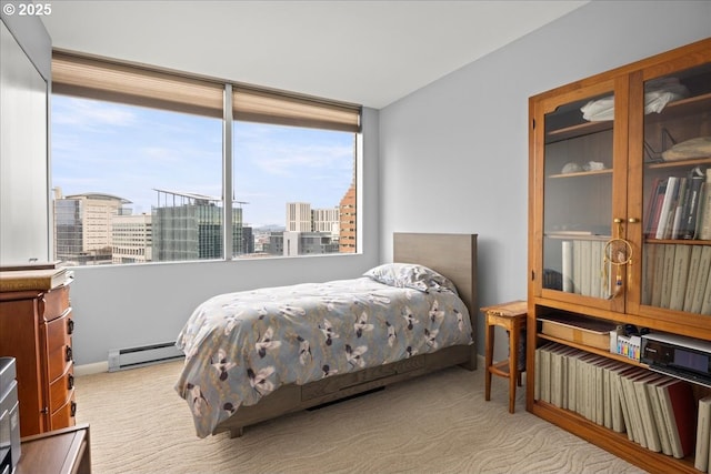 bedroom with baseboard heating, carpet flooring, and a city view