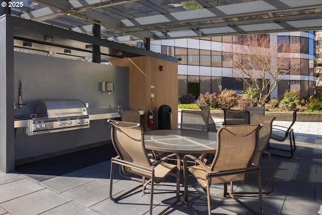 view of patio with outdoor dining area, an outdoor kitchen, and area for grilling