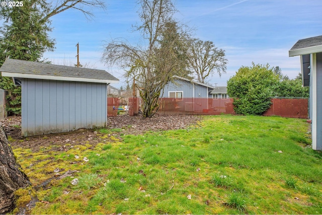 view of yard with an outdoor structure, a storage unit, and a fenced backyard