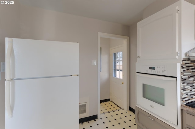 kitchen with tasteful backsplash, white cabinetry, and white appliances