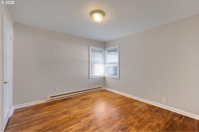 empty room with hardwood / wood-style floors and a baseboard radiator