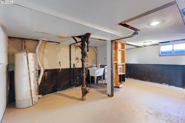 basement featuring sink, a textured ceiling, and gas water heater