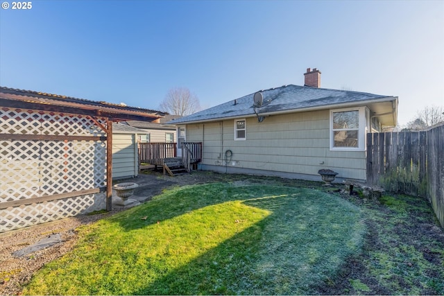 back of house with a deck and a lawn