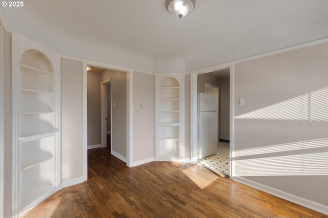 empty room featuring dark wood-type flooring and built in features