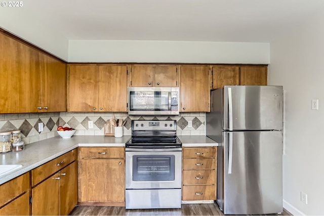 kitchen with light countertops, stainless steel appliances, and brown cabinets