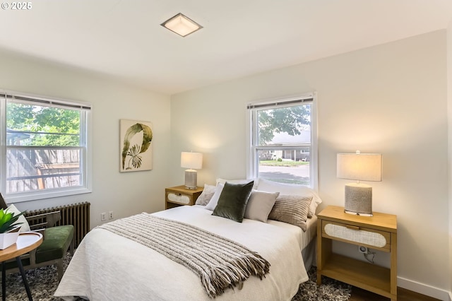 bedroom with radiator heating unit and multiple windows