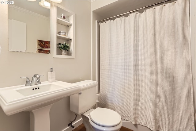 full bath featuring a sink, ornamental molding, and toilet
