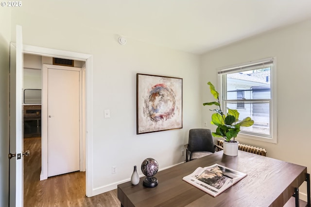 home office with baseboards, visible vents, and wood finished floors