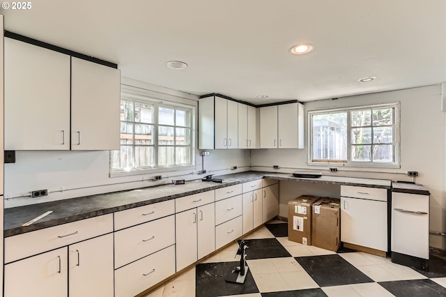kitchen with recessed lighting, white cabinetry, light floors, and dark countertops