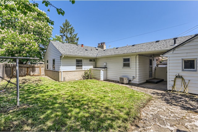 rear view of property with fence, a chimney, and a lawn