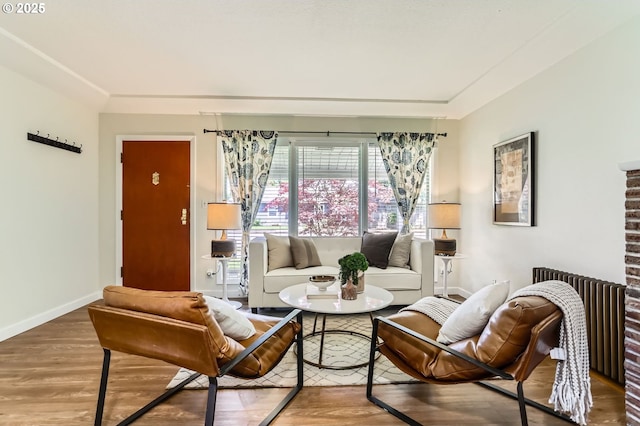 living room with baseboards, radiator heating unit, and wood finished floors