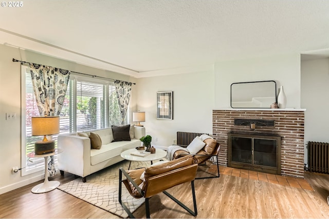 living room with wood finished floors, baseboards, and radiator heating unit