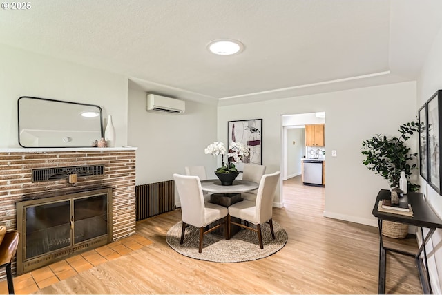dining area featuring a fireplace, a wall mounted AC, radiator heating unit, and light wood-type flooring