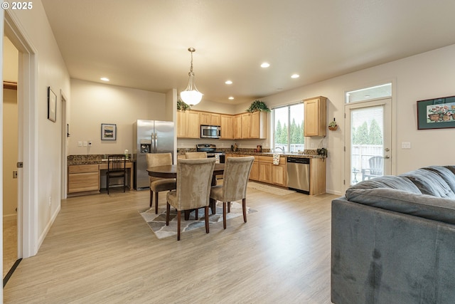 dining room featuring sink and light hardwood / wood-style flooring