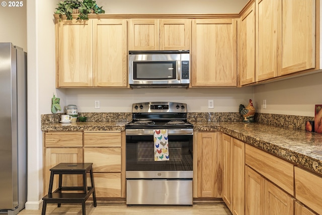 kitchen featuring light brown cabinetry, light hardwood / wood-style flooring, and stainless steel appliances