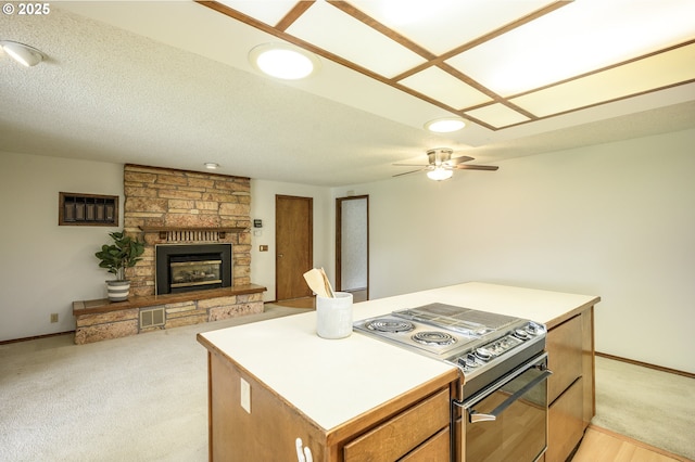 kitchen featuring stainless steel electric range oven, a ceiling fan, visible vents, a center island, and open floor plan