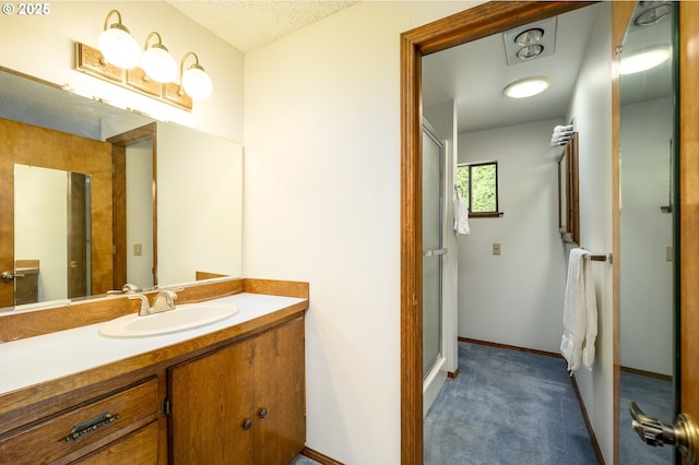 full bathroom featuring a shower stall, vanity, and baseboards