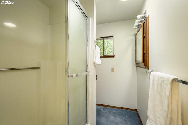 full bathroom with a shower with shower door and baseboards