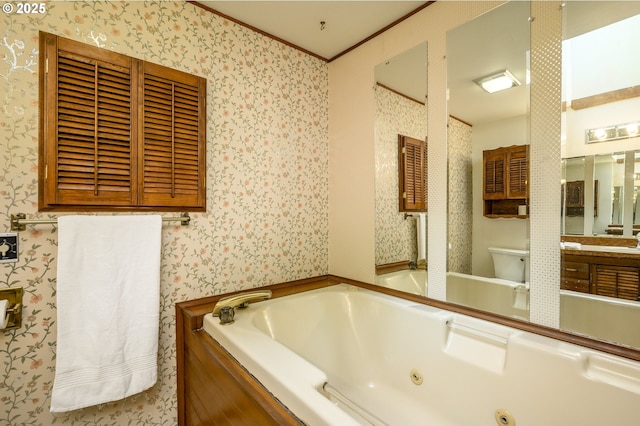 bathroom featuring toilet, wallpapered walls, ornamental molding, and a tub with jets