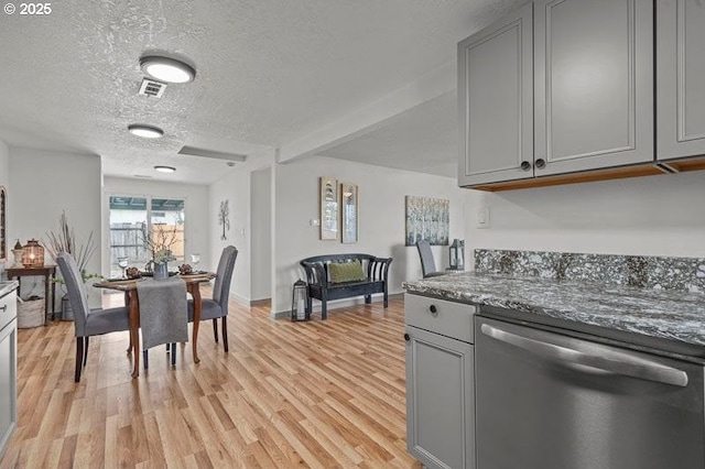 kitchen with a textured ceiling, gray cabinets, light wood finished floors, and dishwasher