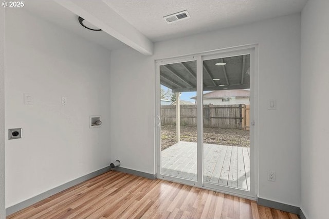 interior space featuring hookup for an electric dryer, laundry area, visible vents, wood finished floors, and hookup for a washing machine