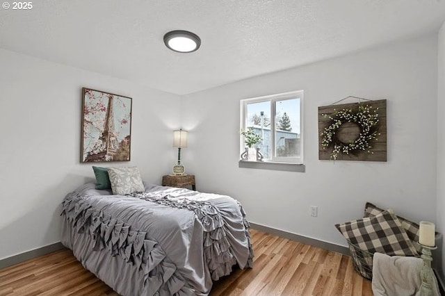 bedroom with baseboards and wood finished floors