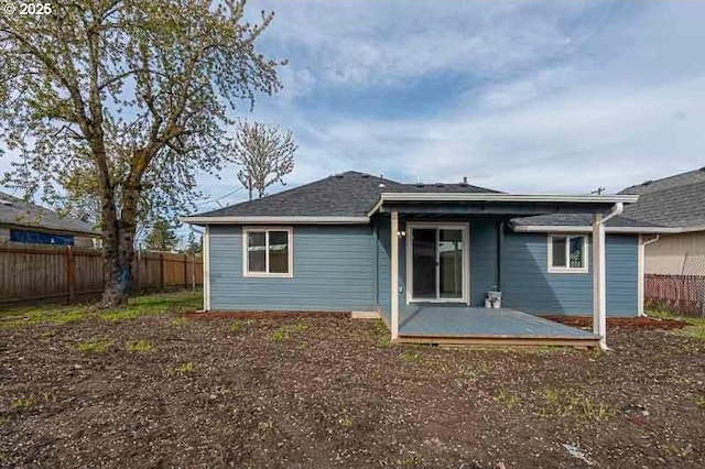 rear view of property featuring fence and a wooden deck