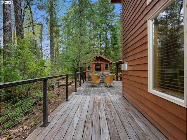 wooden deck with an outbuilding and outdoor dining space