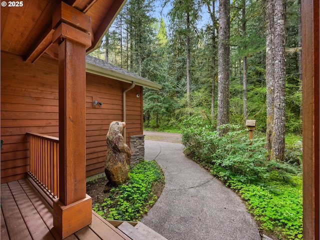 exterior space featuring a forest view and a shingled roof