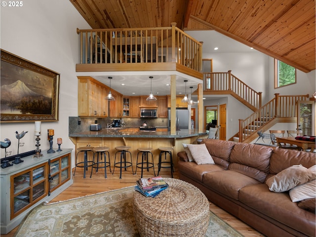 living area featuring light wood-type flooring, stairs, wood ceiling, and high vaulted ceiling