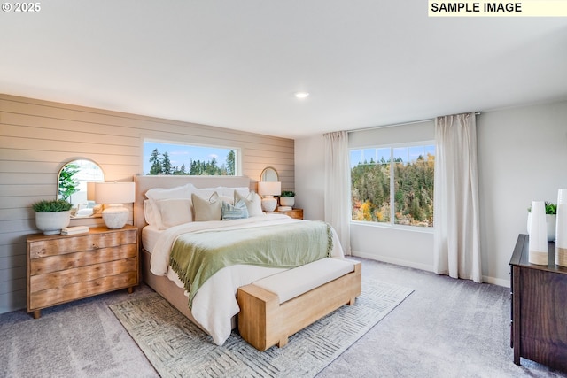 bedroom featuring multiple windows, carpet floors, baseboards, wooden walls, and recessed lighting