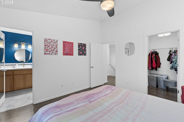 bedroom featuring lofted ceiling, ensuite bathroom, sink, a spacious closet, and a closet