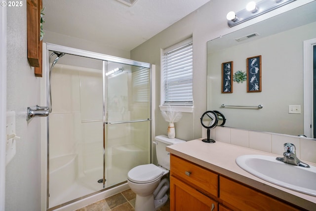 bathroom featuring vanity, toilet, and a shower with shower door