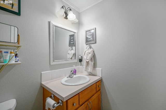 bathroom featuring vanity, ornamental molding, and toilet