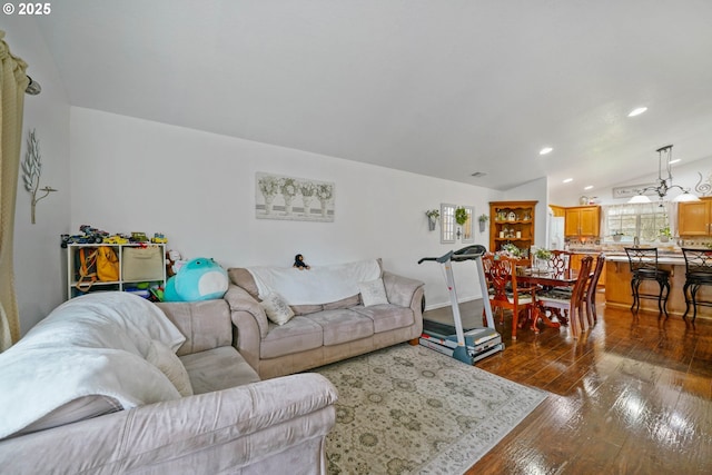 living room with dark hardwood / wood-style flooring and vaulted ceiling