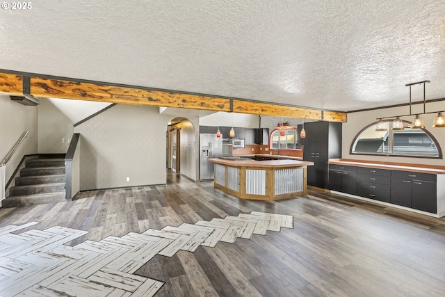 2039 N Jantzen Ave, Portland, OR 97217 - kitchen with stainless steel refrigerator with ice dispenser, a textured ceiling, white microwave, a kitchen island, and dark wood-style floors