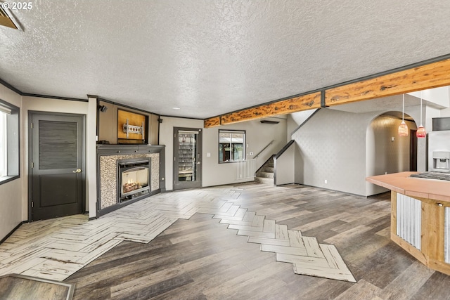 2039 N Jantzen Ave, Portland, OR 97217 - unfurnished living room featuring arched walkways, stairs, a textured ceiling, and wood finished floors