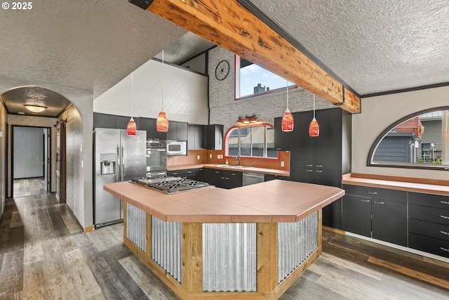 2039 N Jantzen Ave, Portland, OR 97217 - kitchen with stainless steel appliances, tile countertops, a textured ceiling, and dark wood-type flooring