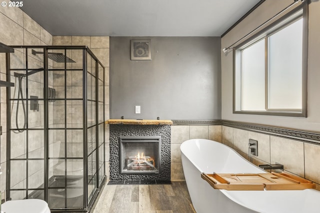 2039 N Jantzen Ave, Portland, OR 97217 - bathroom with tile walls, a tile fireplace, a shower stall, and wood finished floors