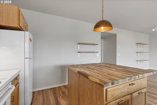 kitchen with wooden counters, a center island, hanging light fixtures, light hardwood / wood-style flooring, and white refrigerator