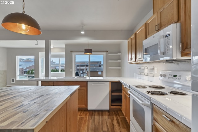 kitchen featuring light wood-type flooring, sink, white appliances, and decorative light fixtures