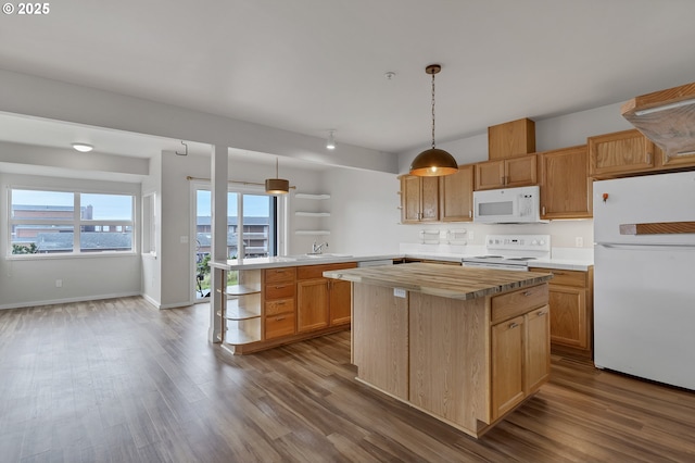 kitchen featuring a center island, hardwood / wood-style flooring, kitchen peninsula, pendant lighting, and white appliances