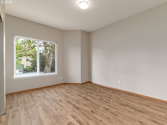 unfurnished room with baseboards and light wood finished floors